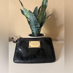 Black wristlet from Michael Kors with metal gold covered plate and gold zipper